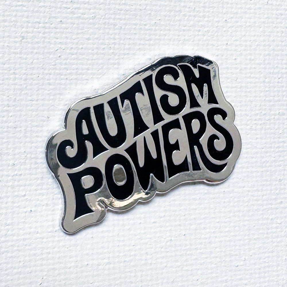 Silver-plated hard enamel pin featuring the words Autism Powers in bold black retro lettering
