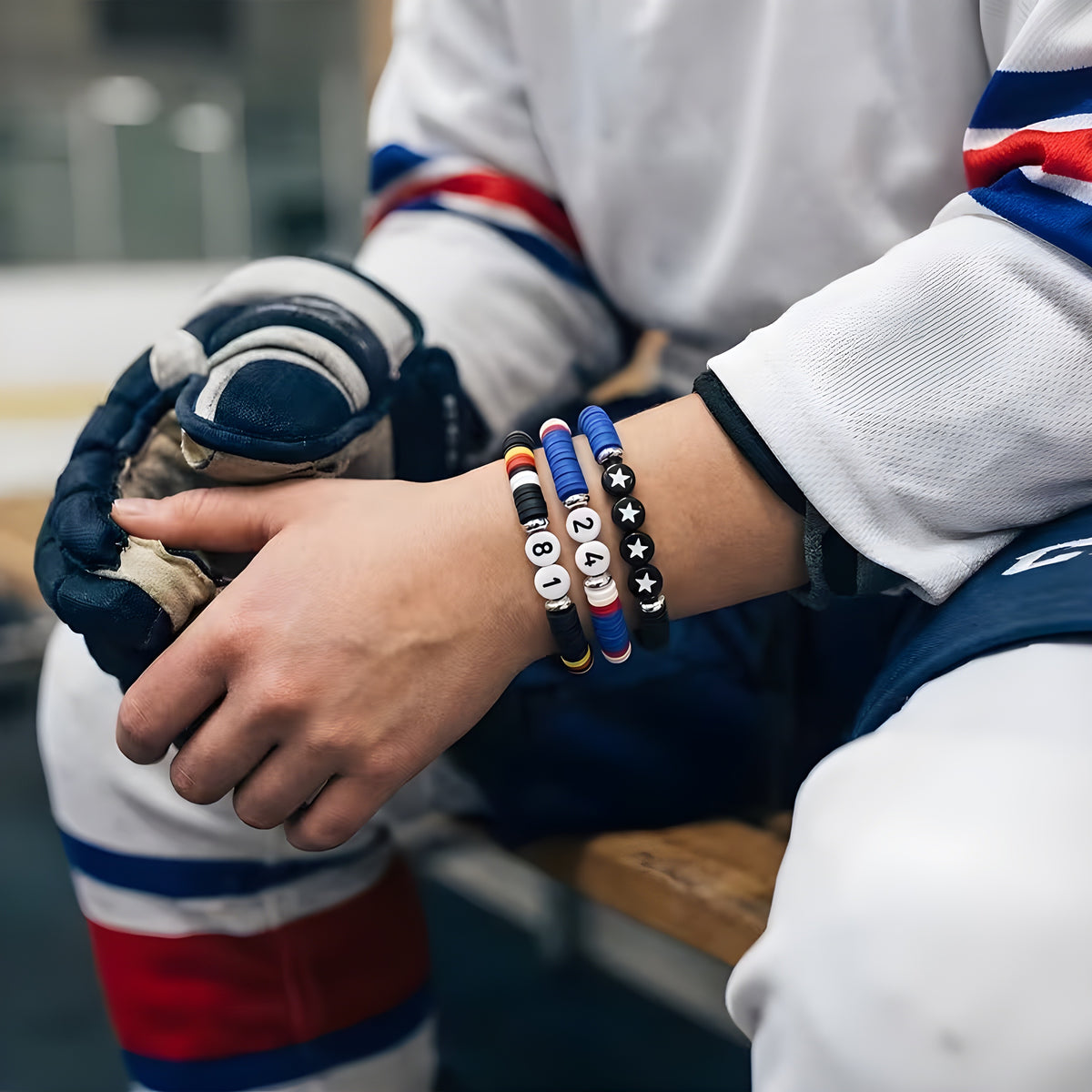 Three Heated Rivalry hockey bracelets with 81, 24 and star beads worn by a hockey player model