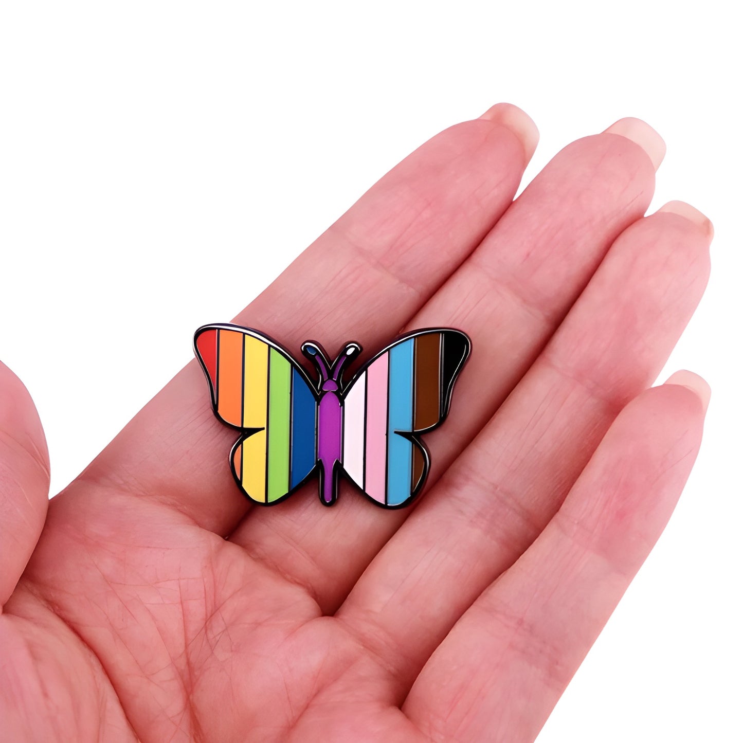 Butterfly enamel pin featuring rainbow and Progress Pride flag colors held in a hand