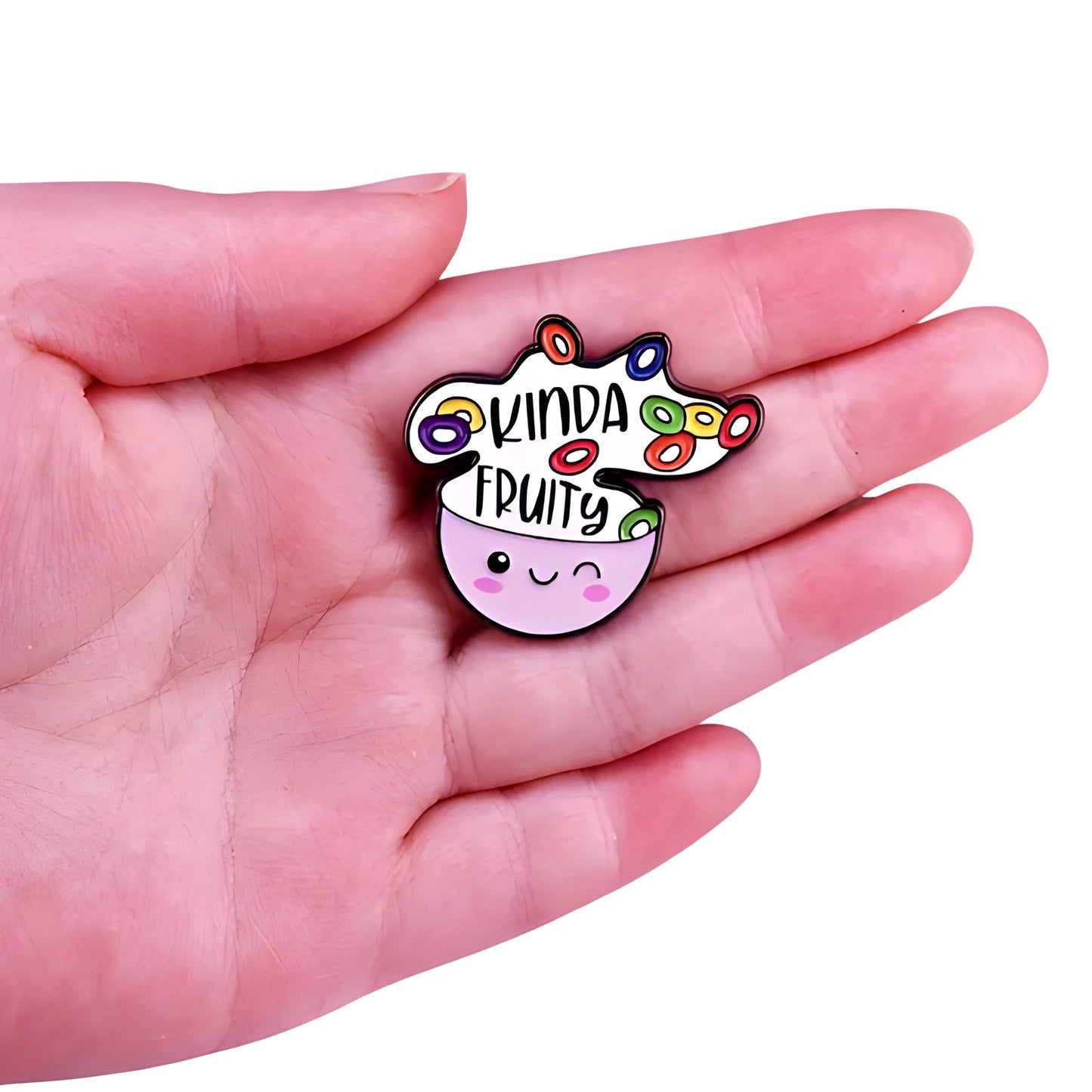 Cute enamel pin featuring smiling cereal bowl and the phrase “Kinda Fruity” held in a hand