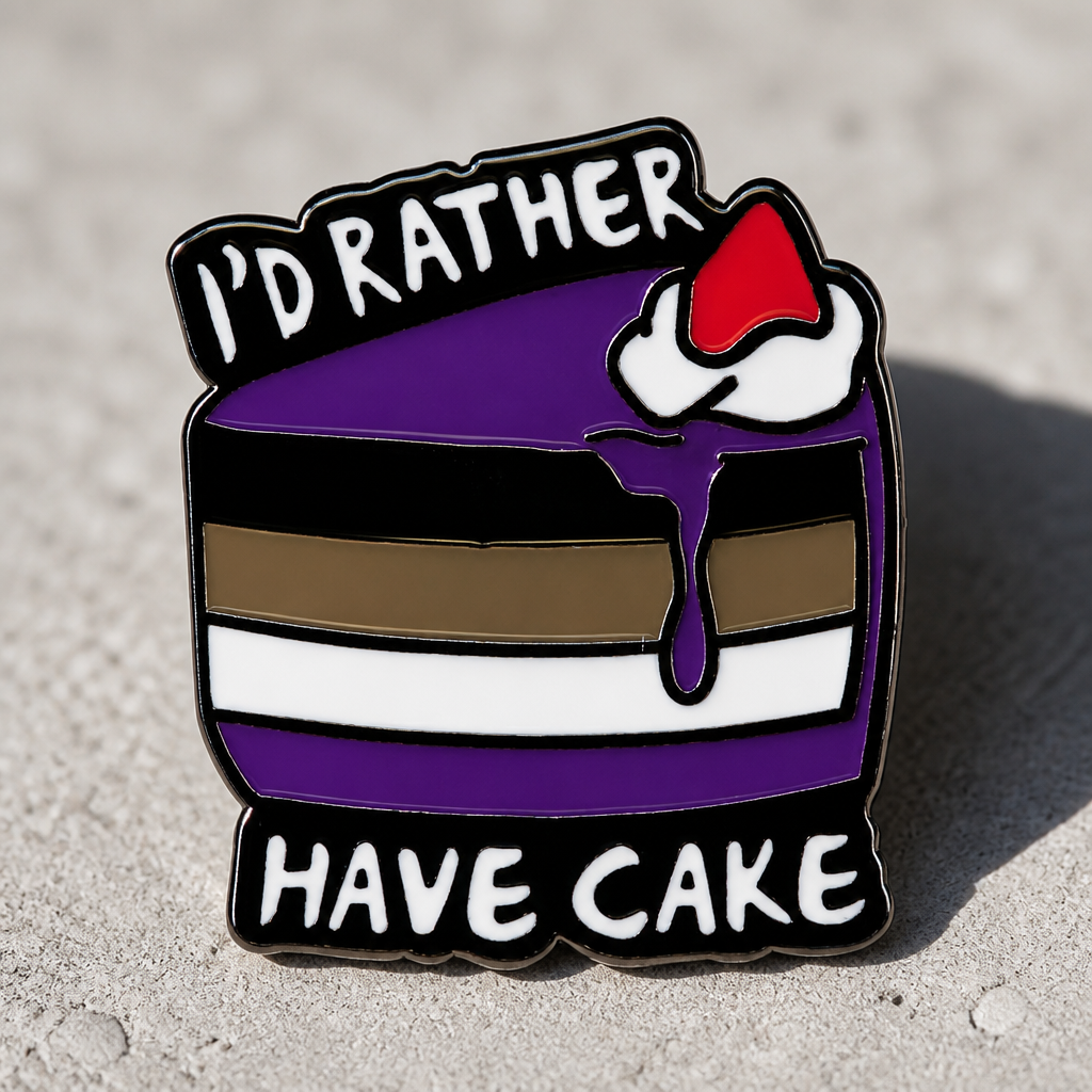 Ace Pride enamel pin with cake design and “I’d Rather Have Cake” text on a concrete surface