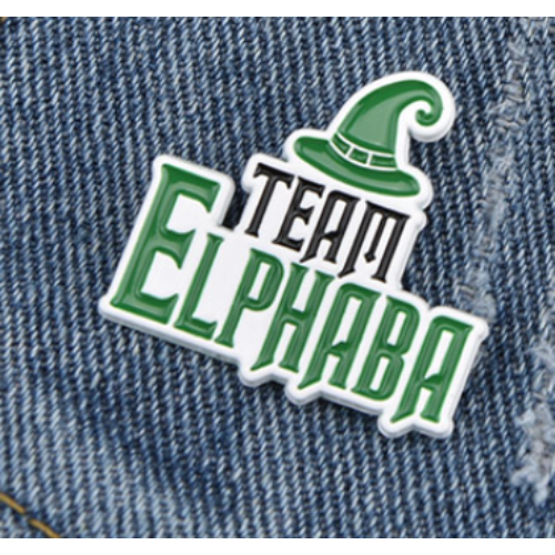Green Team Elphaba musical theater fandom pin with witch hat detail on denim fabric