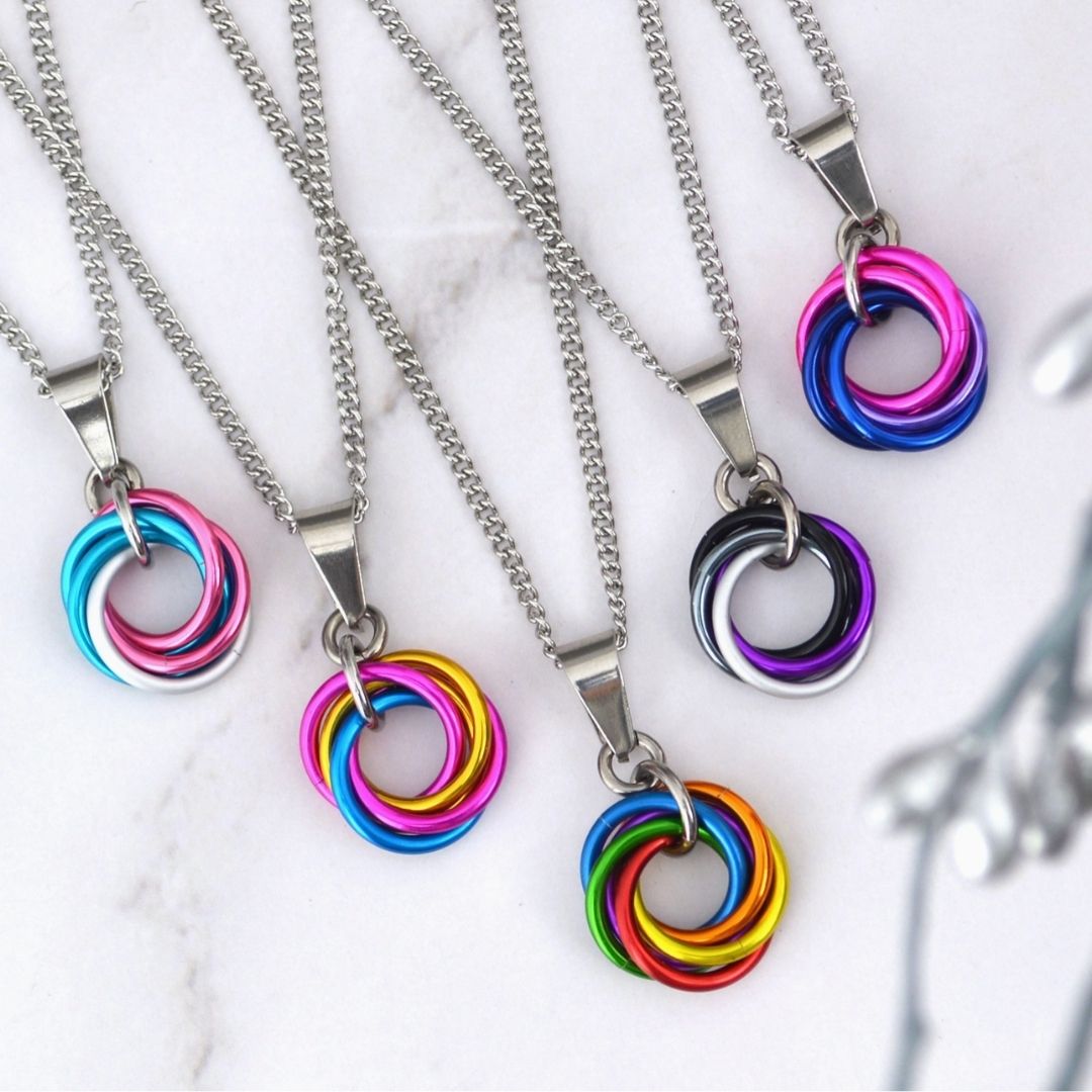 Assorted Pride Swirl Pendant Necklaces featuring colorful identity-inspired interlocking rings on silver-tone chains