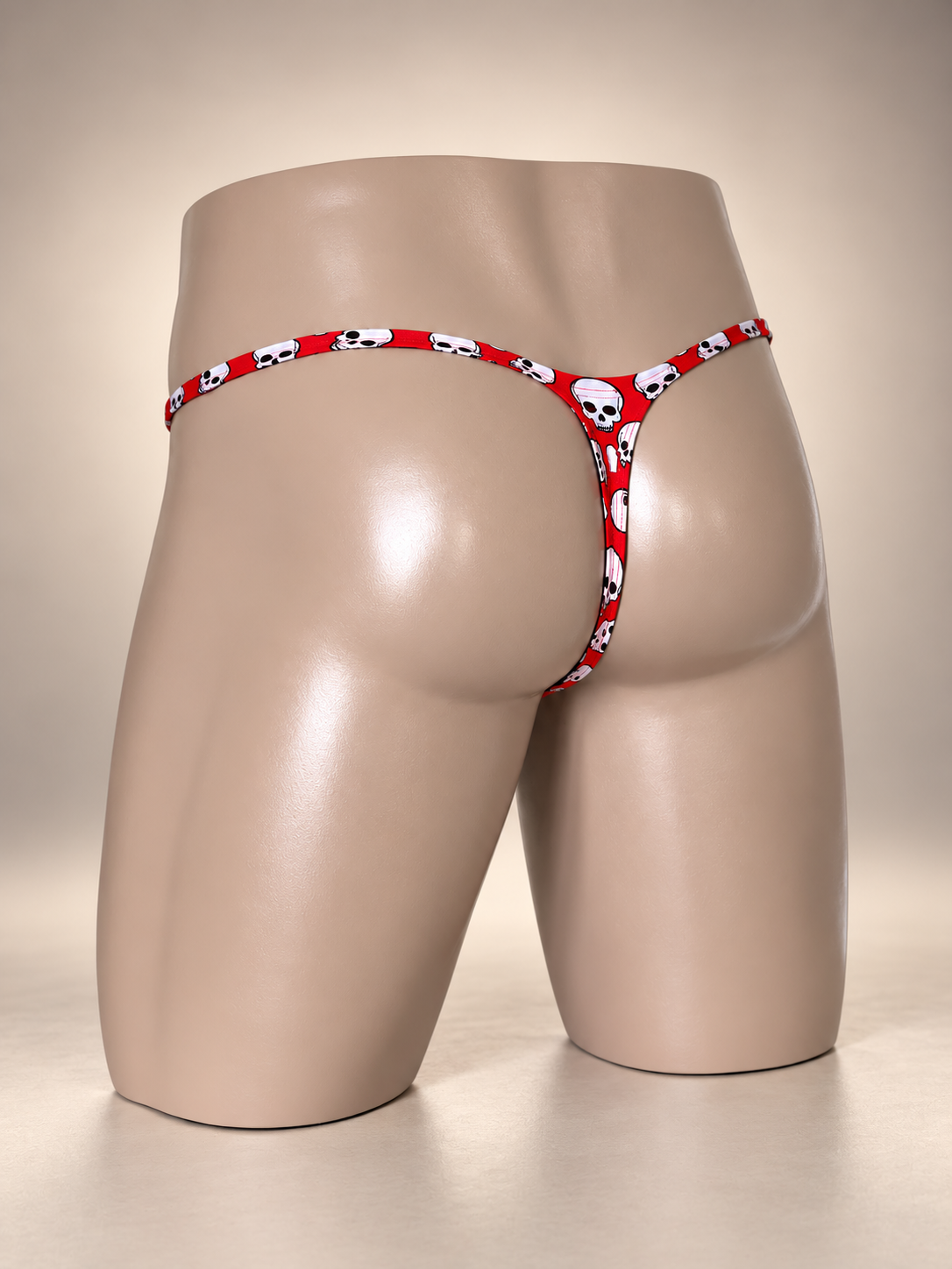 Front view of Skull Candy Muscle Thong featuring scattered white skulls with black details on red, men's Muscle thong by PapiMalo Gear.