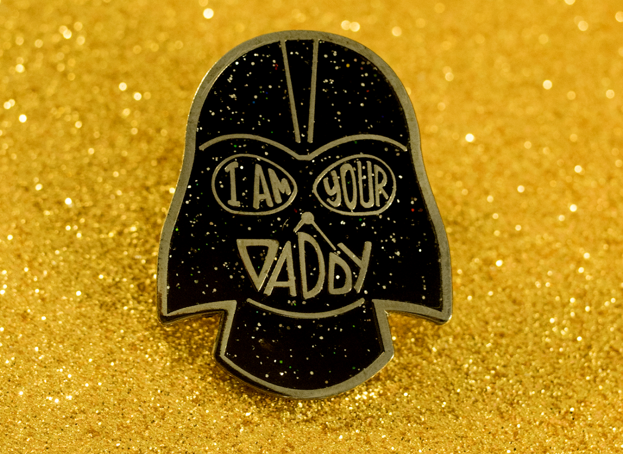 Black glitter enamel pin reading I Am Your Daddy with bold graphic artwork and gold-tone details