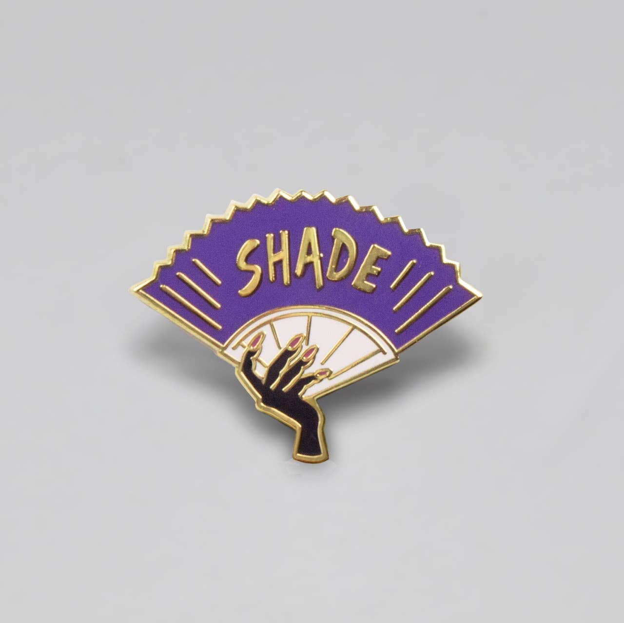 Purple Shade enamel pin featuring a dramatic folding fan design with gold-tone details