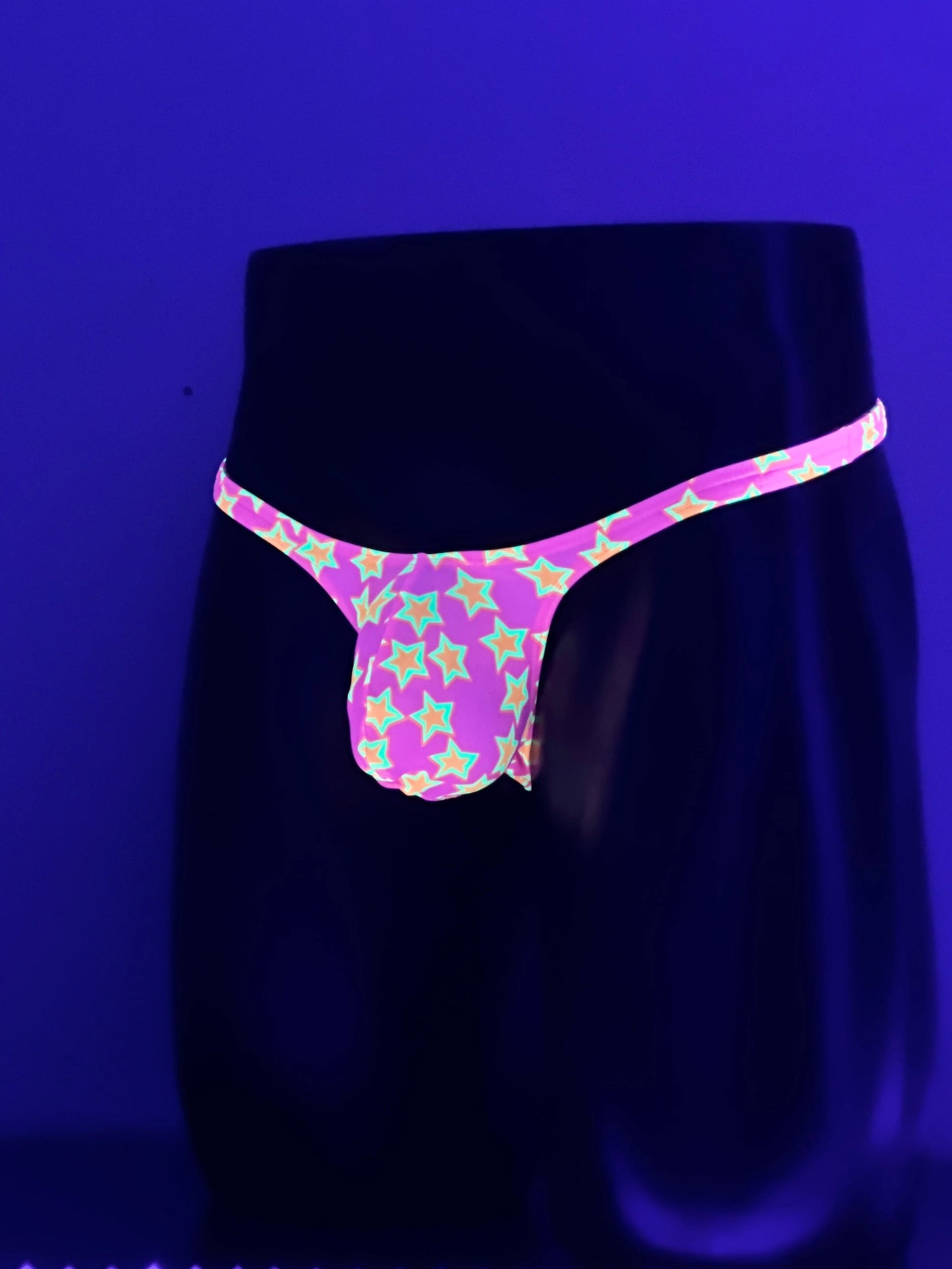 Alternate Front View of Star Power men’s Muscle thong glowing under UV blacklight