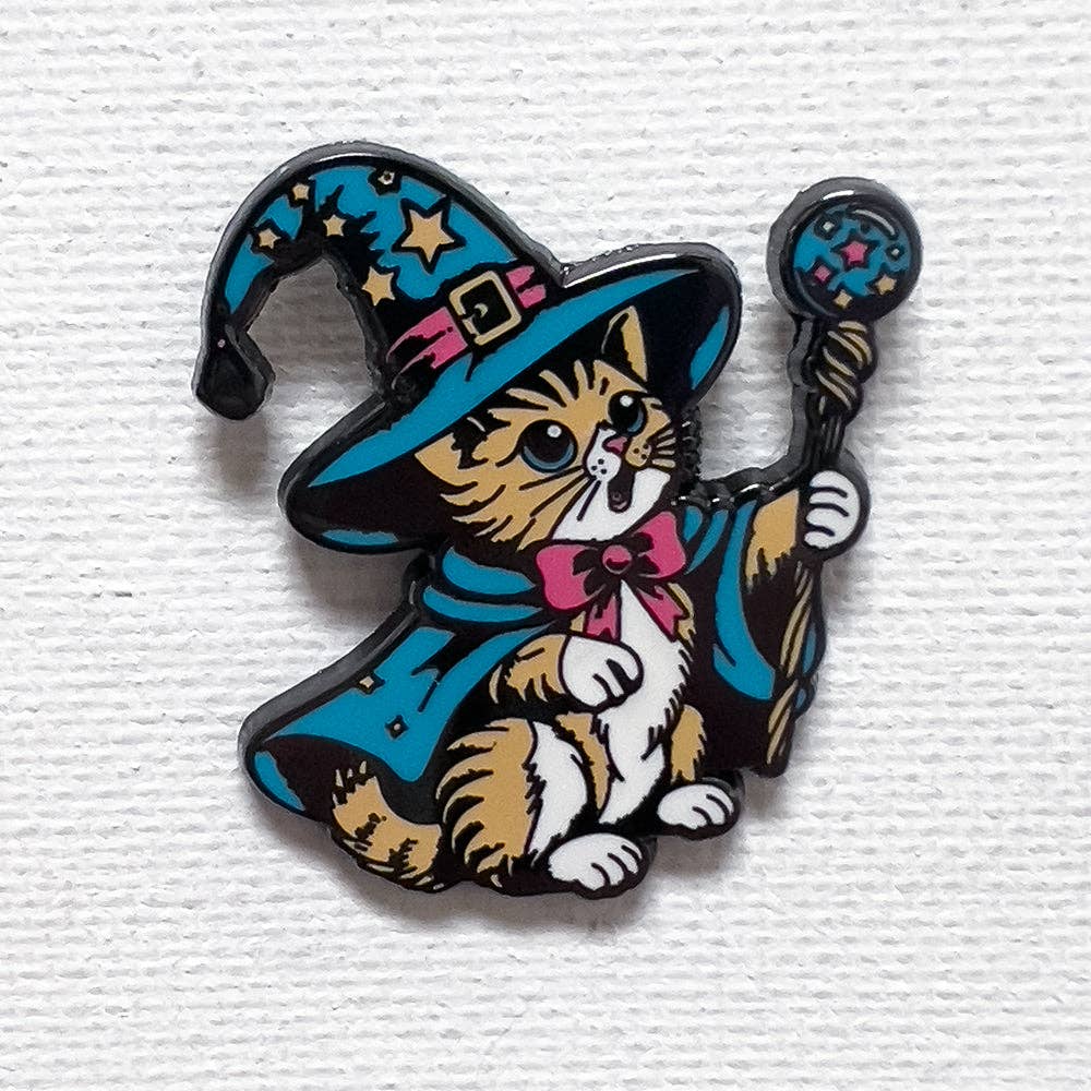 Hard enamel pin featuring a cat dressed as a wizard with a blue star-covered hat, cloak, and magical staff