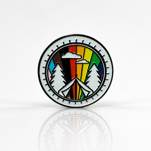 Round rainbow camping pride pin featuring mountains trees and colorful LGBTQ pride landscape design
