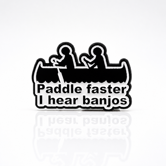 Funny enamel pin featuring two people in a canoe with Paddle Faster I Hear Banjos text