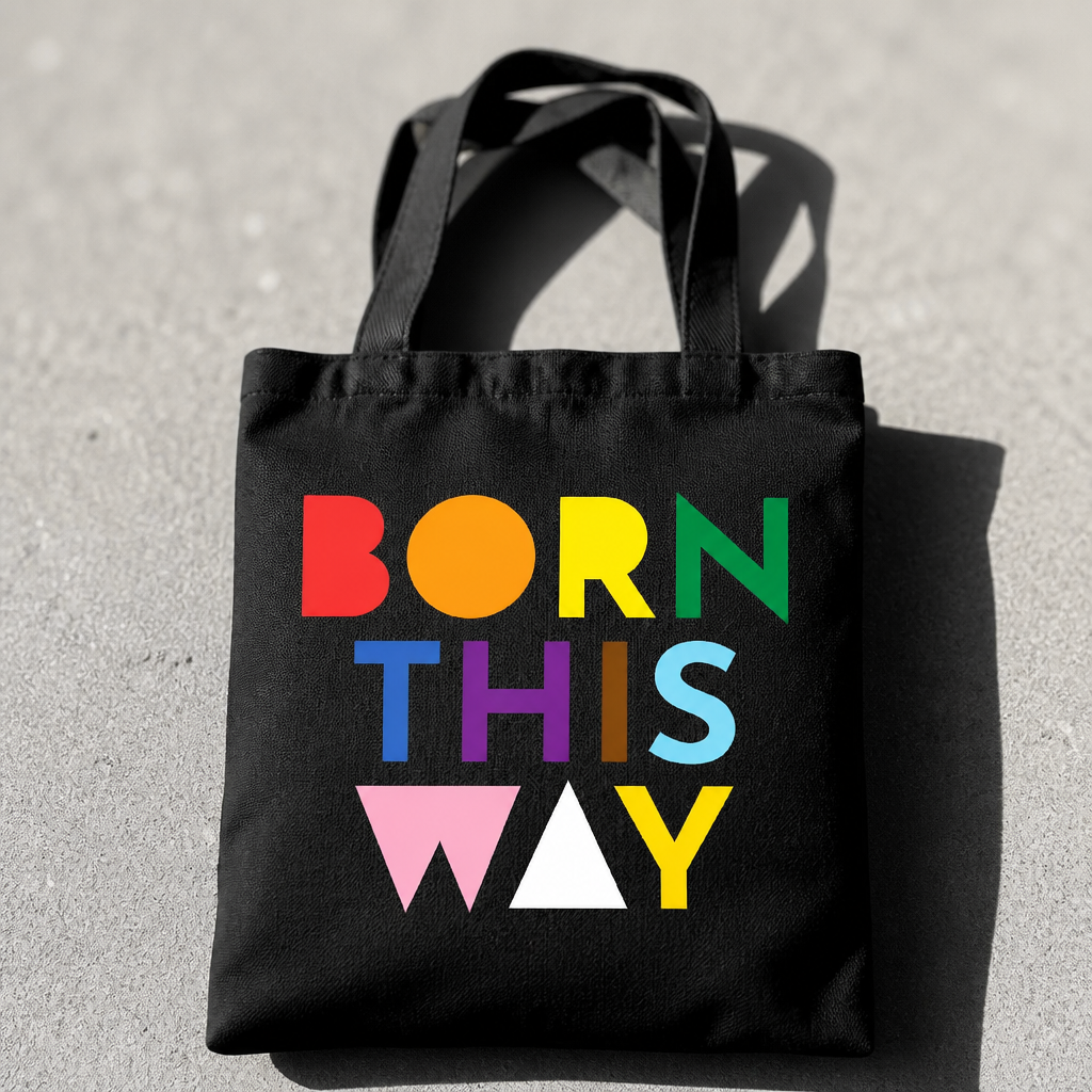 Black Born This Way Pride tote bag with colorful typography design on a concrete surface