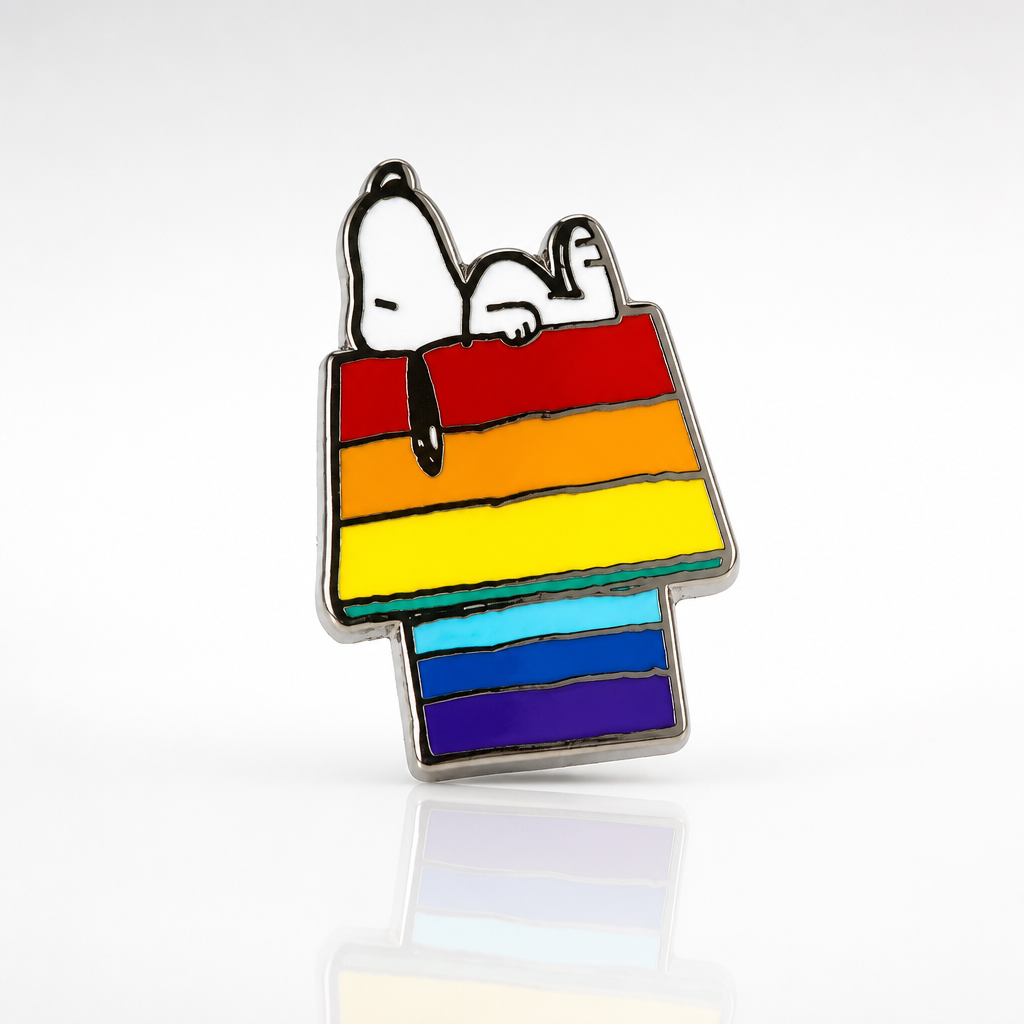 Official Peanuts enamel pin featuring Snoopy resting on a rainbow-colored doghouse