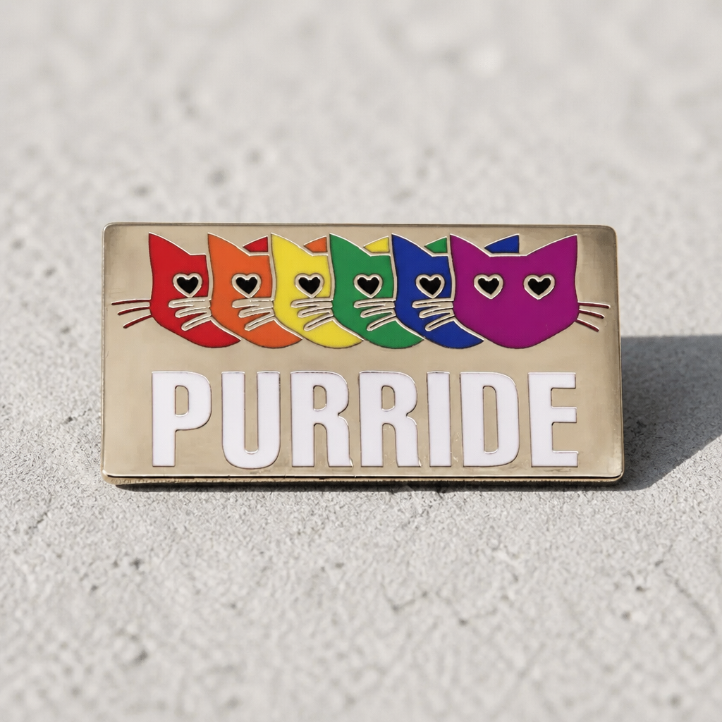 Purride enamel pin featuring six rainbow-colored cats and Pride-inspired design on a concrete surface
