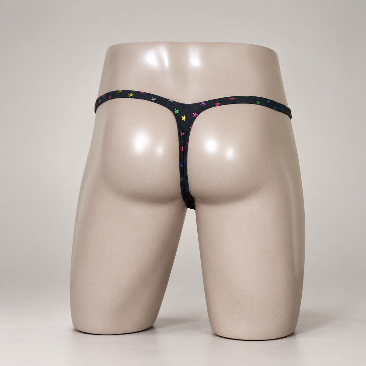 Rear View of Rainbow Stardust black and rainbow star-print men’s Muscle thong by PapiMalo Gear
