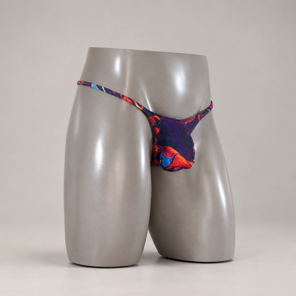 Angled view of Molten Ember fluid-print men's Muscle thong by PapiMalo Gear