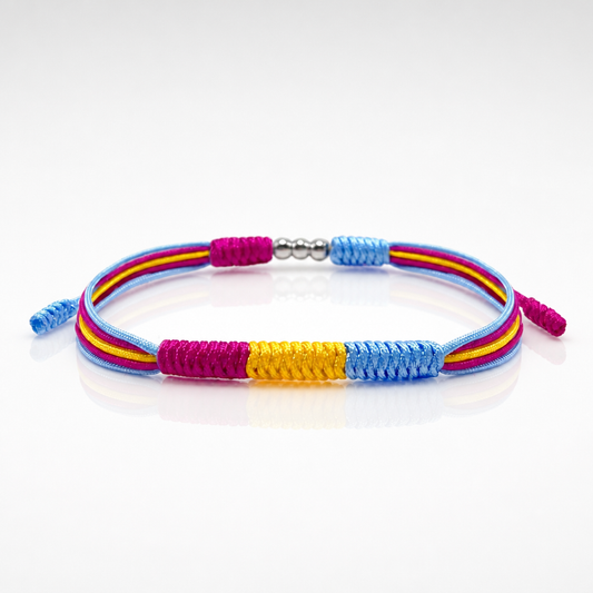 Pansexual Pride braided cord bracelet with adjustable closure in pink yellow and blue pride colors on a white surface