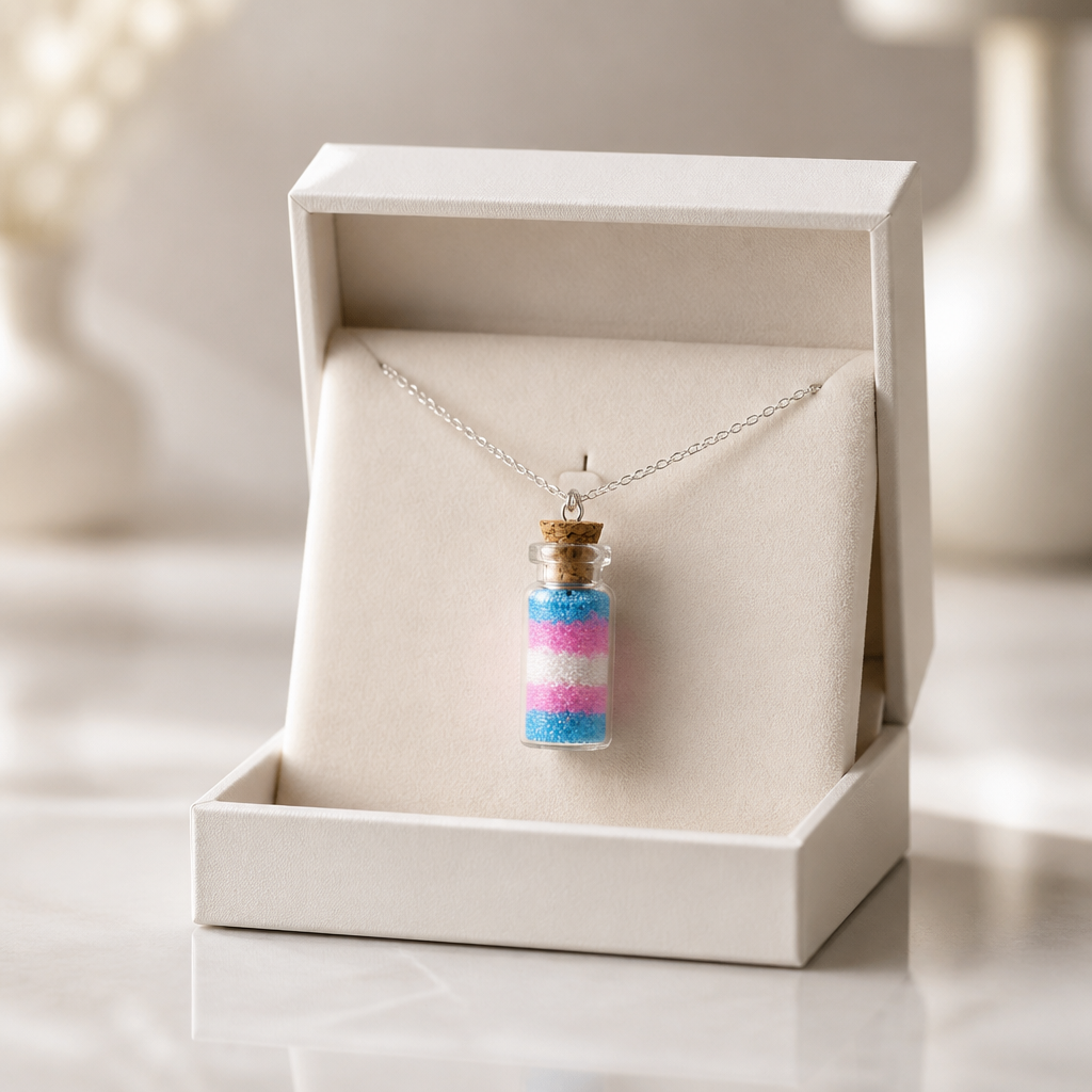 Trans pride bottle necklace with layered pink blue and white micro-beads inside tiny glass vial pendant in a jewelry box