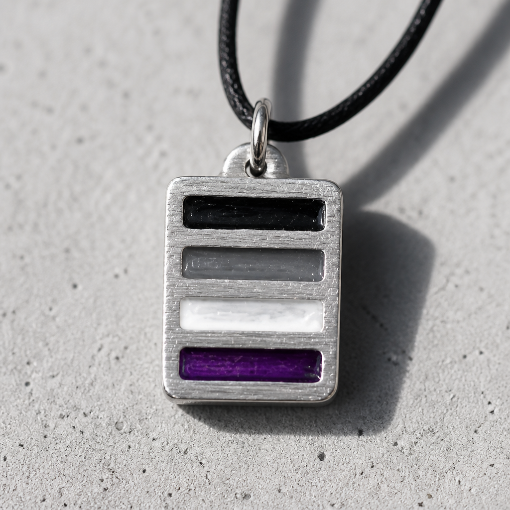 Handcrafted pewter pendant featuring the Asexual Pride flag in a modern geometric design on an adjustable black cord on a cement surface