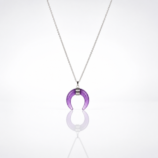 Silver-tone necklace featuring a polished genuine amethyst crescent moon pendant on a delicate chain.