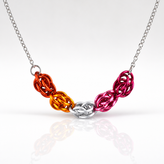 Hand-linked lesbian pride chainmail necklace featuring orange, white, pink, and magenta aluminum rings on an adjustable stainless steel chain on a white background