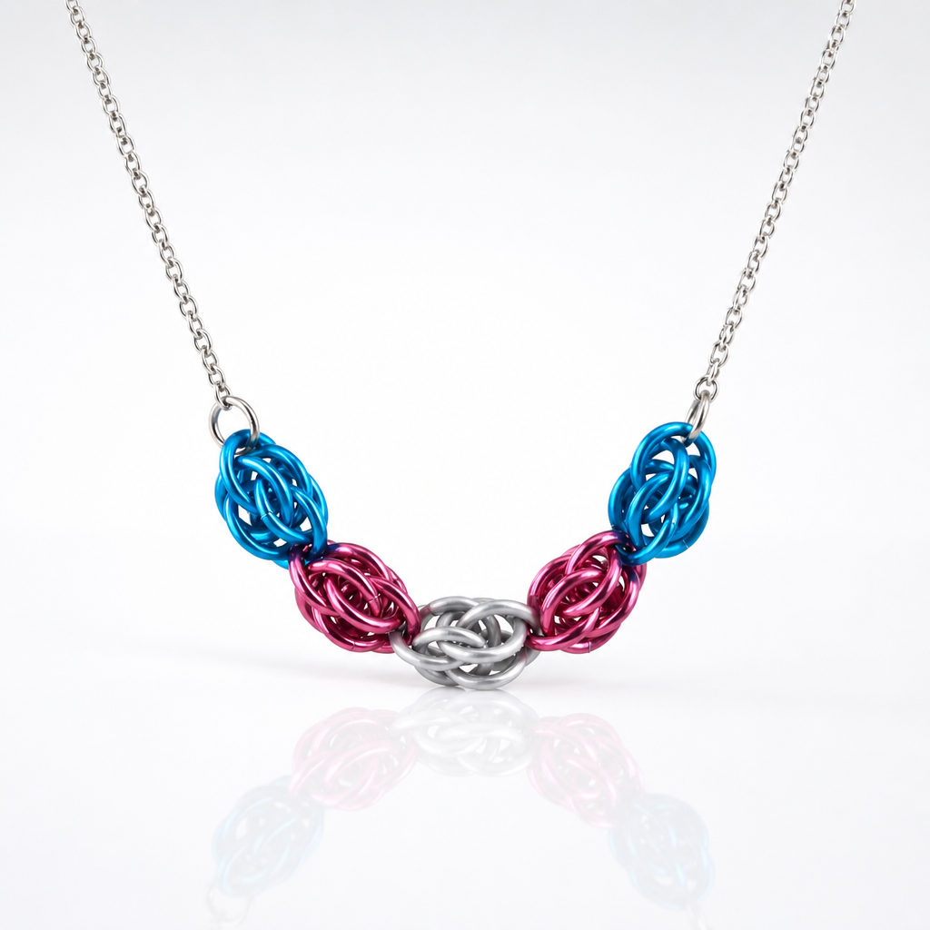 Hand-linked transgender pride chainmail necklace featuring blue, pink, and white aluminum rings on an adjustable stainless steel chain on a white background