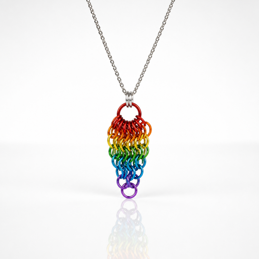 Hand-linked rainbow chainmail cluster pendant featuring cascading aluminum rings on an adjustable stainless steel chain on a white background