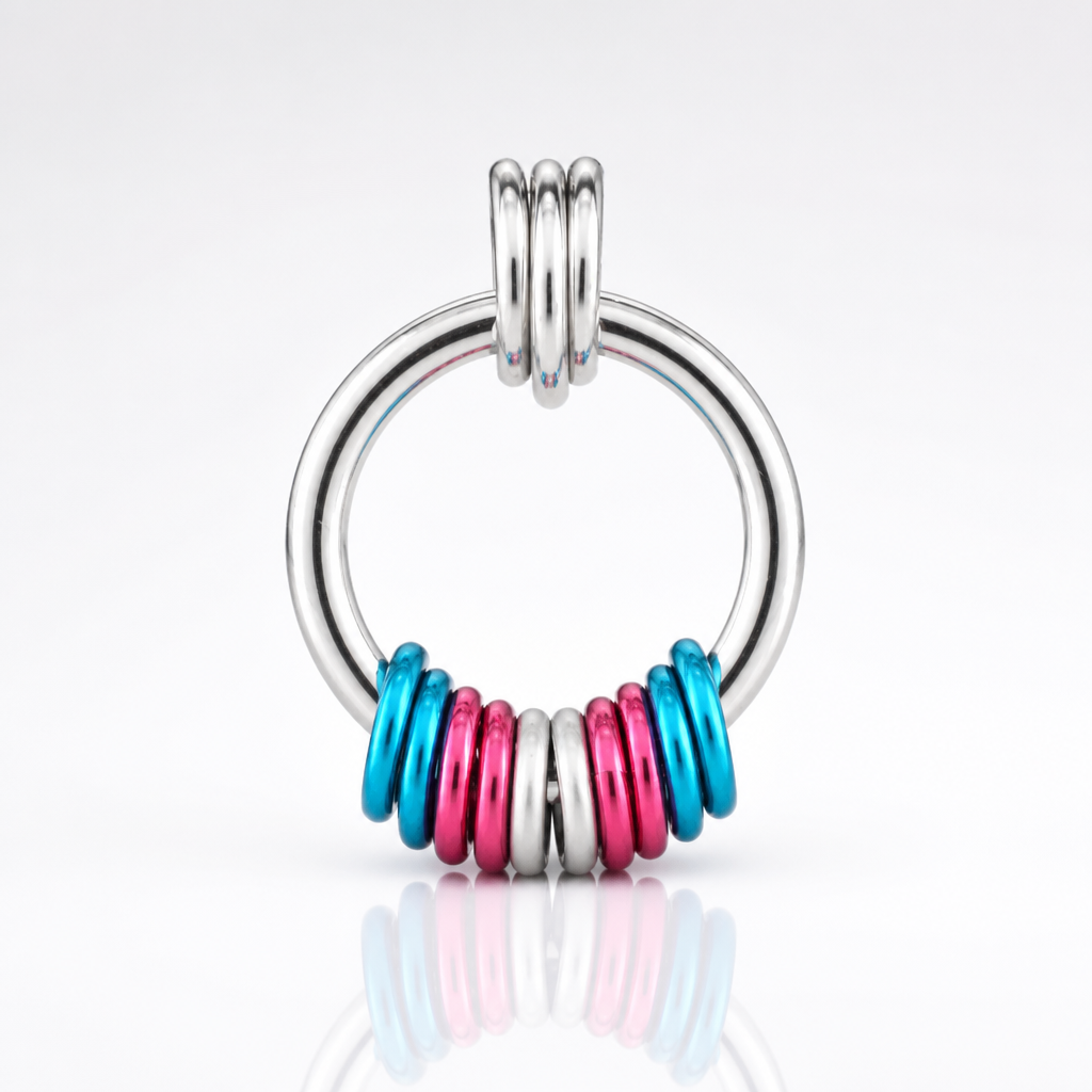 Handcrafted Transgender Pride coil fidget necklace featuring free-spinning pink, white, and blue aluminum rings on an adjustable stainless steel chain on a white background