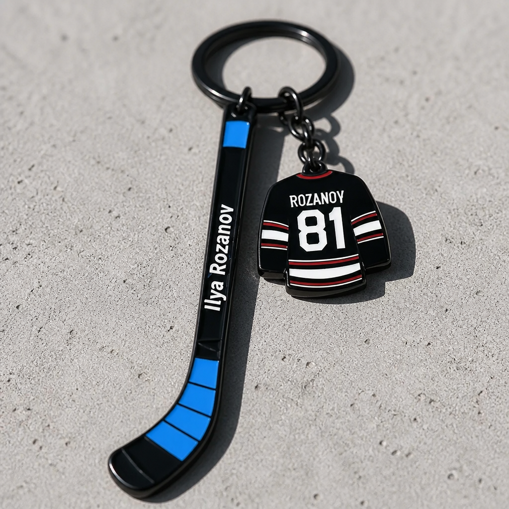 Heated Rivalry Rozanov hockey stick enamel keychain with miniature jersey charm on a concrete surface