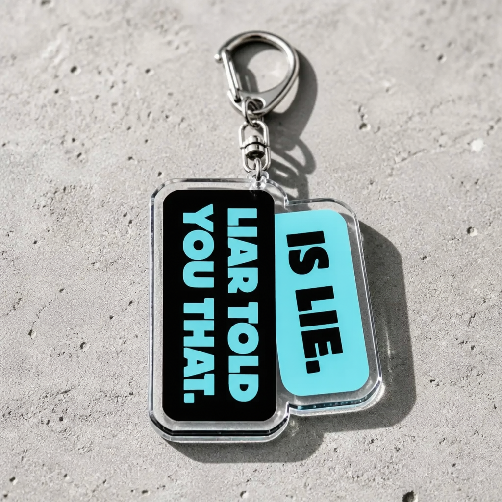 Heated Rivalry acrylic keychain featuring “Liar, Liar Told You That” quote in blue and black design on a concrete surface