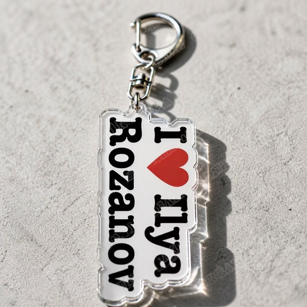 I Love Ilya Rozanov Heated Rivalry keychain with red heart and silver-tone clasp displayed on a concrete surface