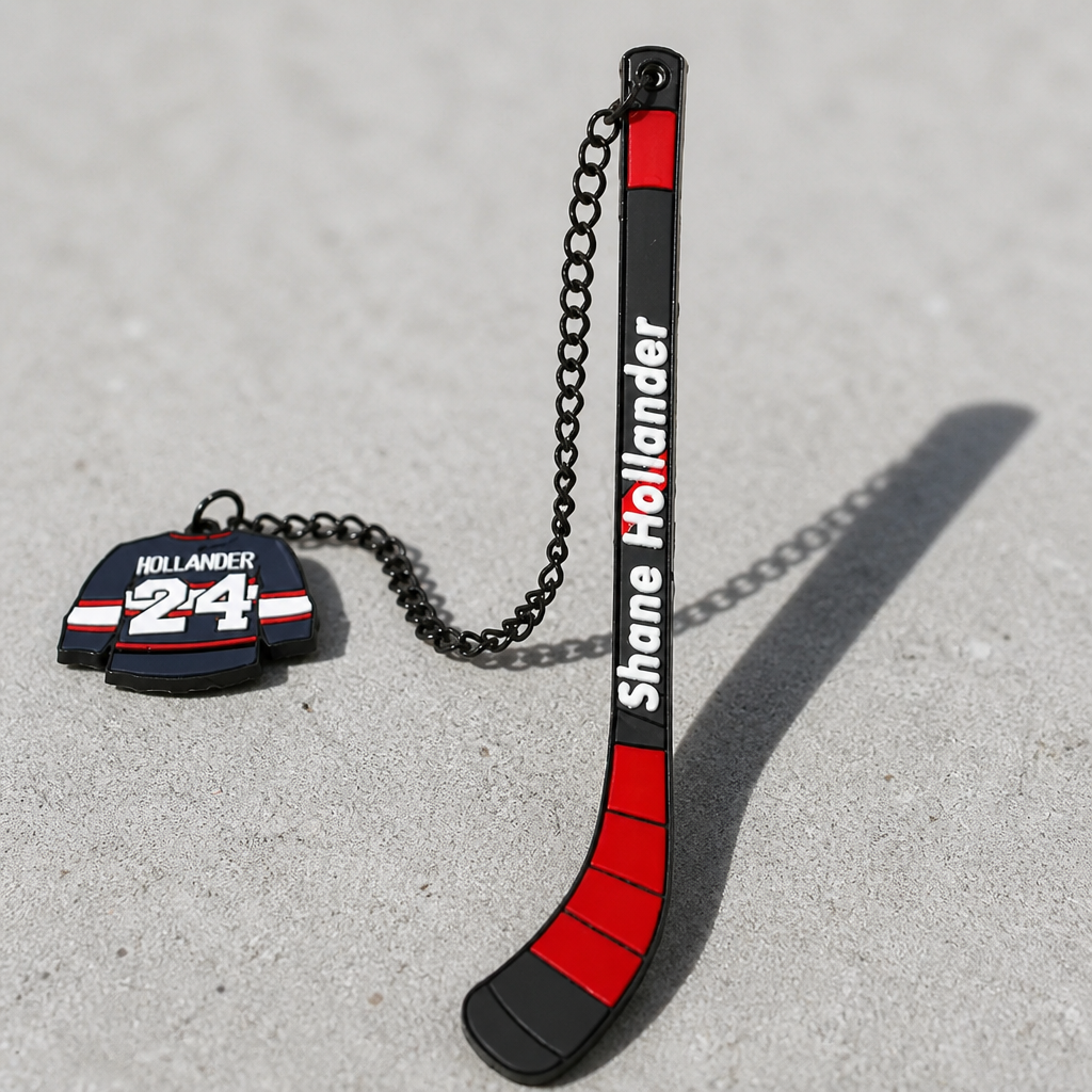 Heated Rivalry Hollander hockey stick metal bookmark with miniature jersey charm on a concrete surface