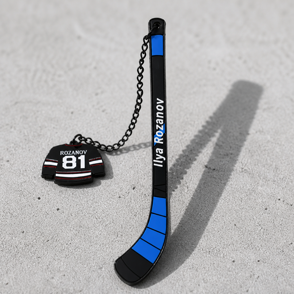 Heated Rivalry Rozanov hockey stick metal bookmark with miniature jersey jersey charm on a concrete surface