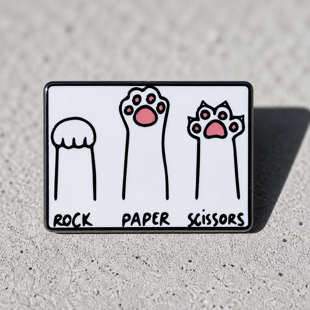 Cats Playing Rock Paper Scissors enamel pin featuring kitten paws and claws design on a cement surface