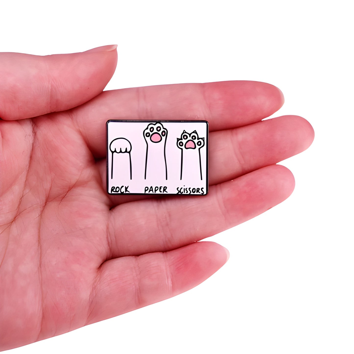 Cats Playing Rock Paper Scissors enamel pin featuring kitten paws and claws design held in a hand