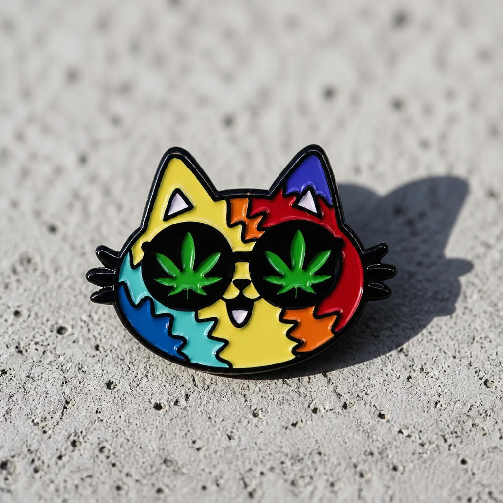 Rainbow Stoner Kitty enamel pin featuring colorful cat face with cannabis leaf eyes on a concrete surface