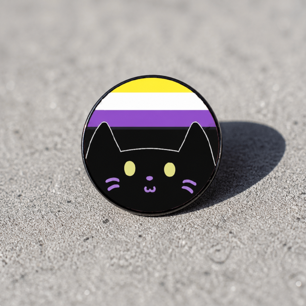 Hard enamel pin featuring a cute black kitty in front of the Nonbinary Pride flag in yellow, white, purple, and black on a concrete surface