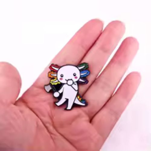 Cute Very Gay Axolotl enamel pin with rainbow frills and pastel kawaii salamander design held in a hand