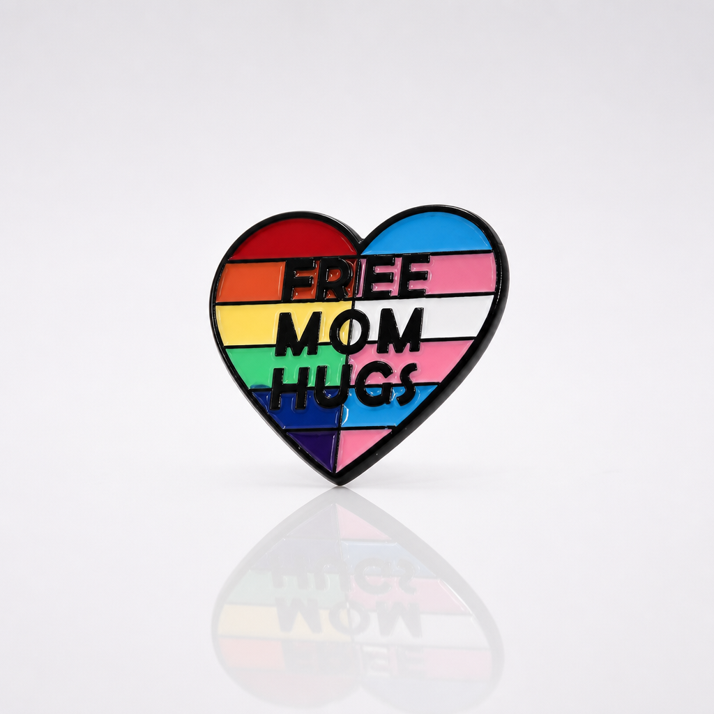 Heart-shaped Free Mom Hugs enamel pin with rainbow and trans pride flag colors