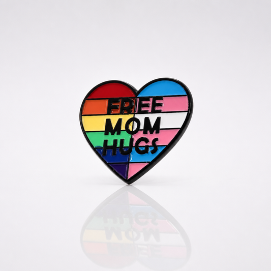Heart-shaped Free Mom Hugs enamel pin with rainbow and trans pride flag colors