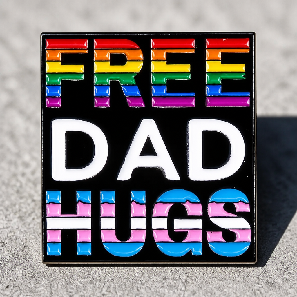 Free Dad Hugs enamel pin with Progress Pride rainbow colors on black background on a concrete surface