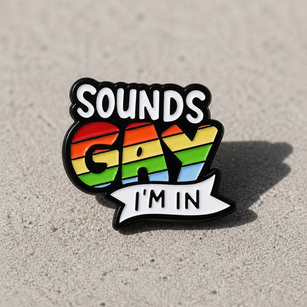 Sounds Gay I’m In enamel pin with rainbow Pride lettering and funny LGBTQ phrase on a concrete surface