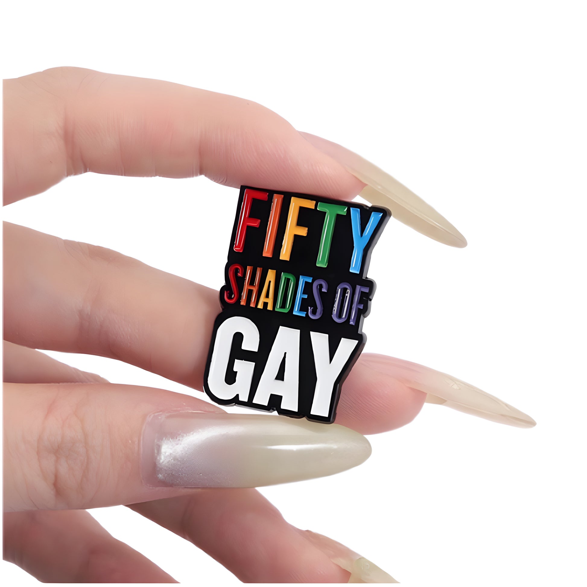 Rainbow enamel pin reading “Fifty Shades of Gay” held between fingers