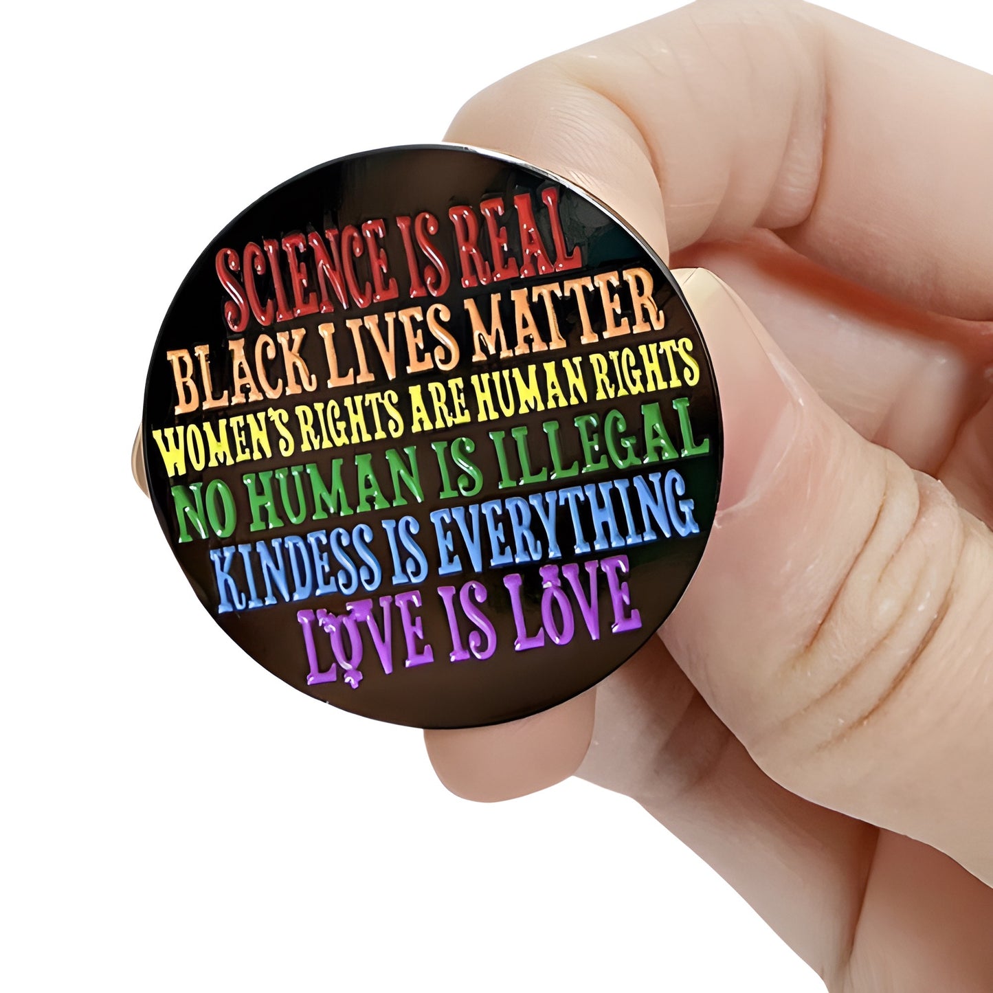 Science Is Real enamel pin with rainbow progressive human rights messaging held by hand