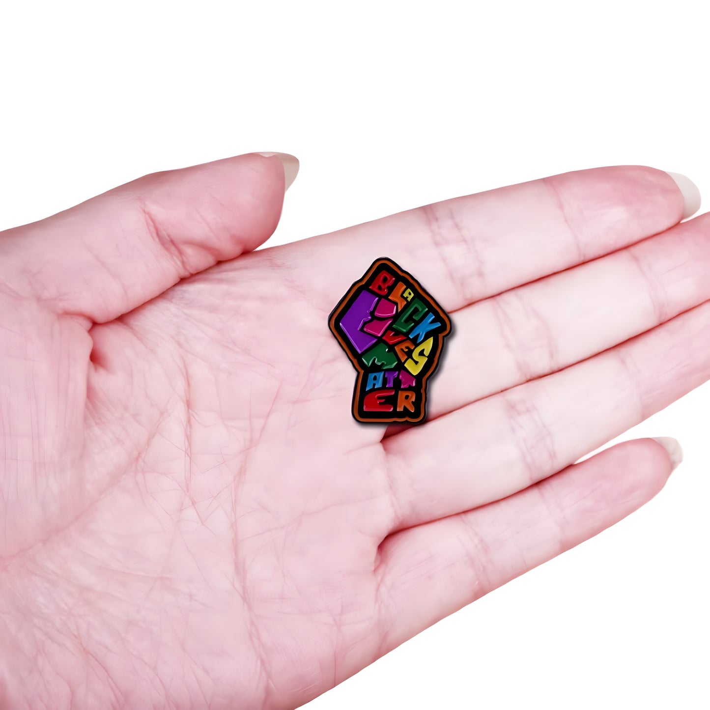 Colorful Black Lives Matter enamel pin with raised fist artwork and rainbow lettering held in a hand