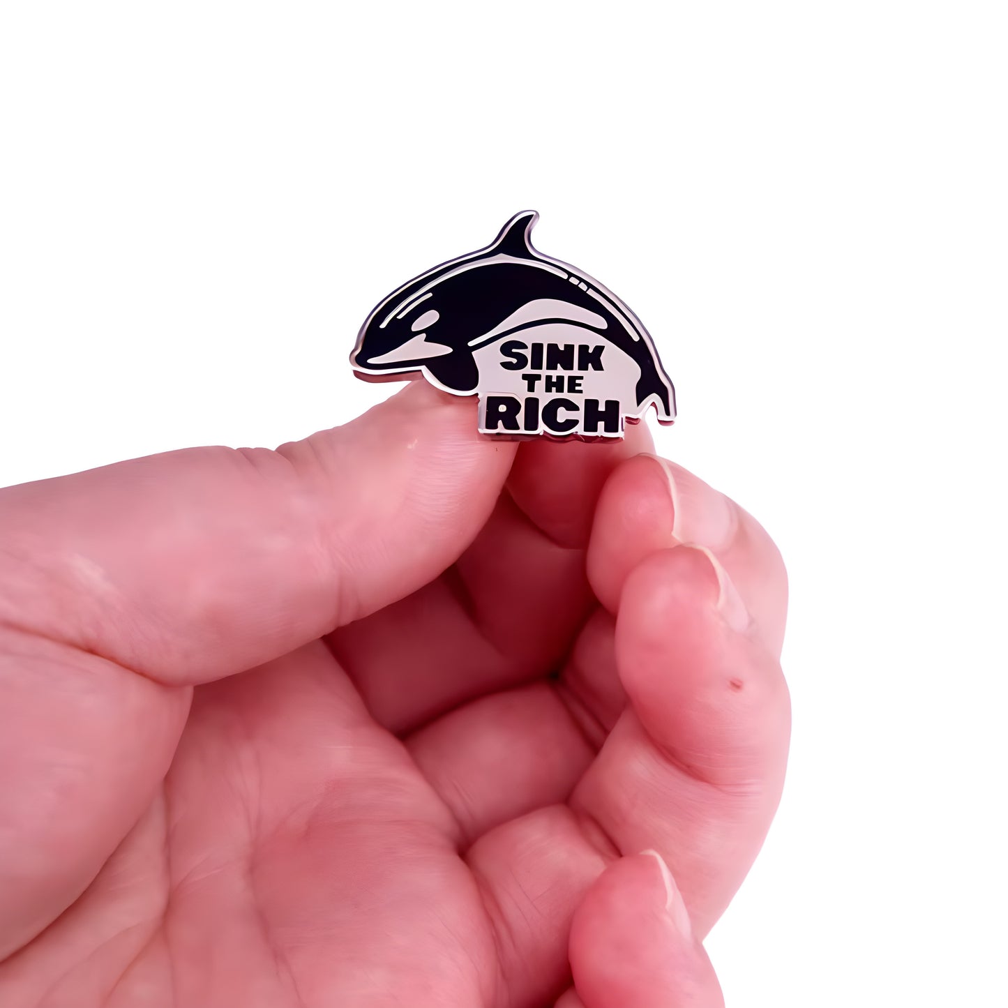 Black and white Sink The Rich orca enamel pin with killer whale design held in a hand
