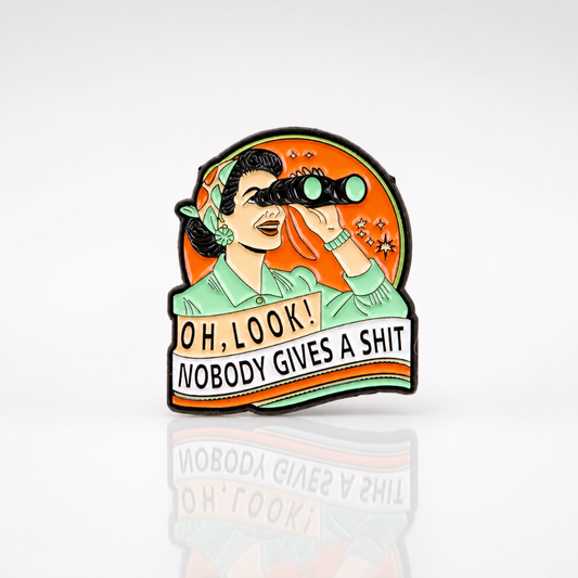 Retro style enamel pin with woman using binoculars and the phrase “Oh Look, Nobody Gives a Shit”
