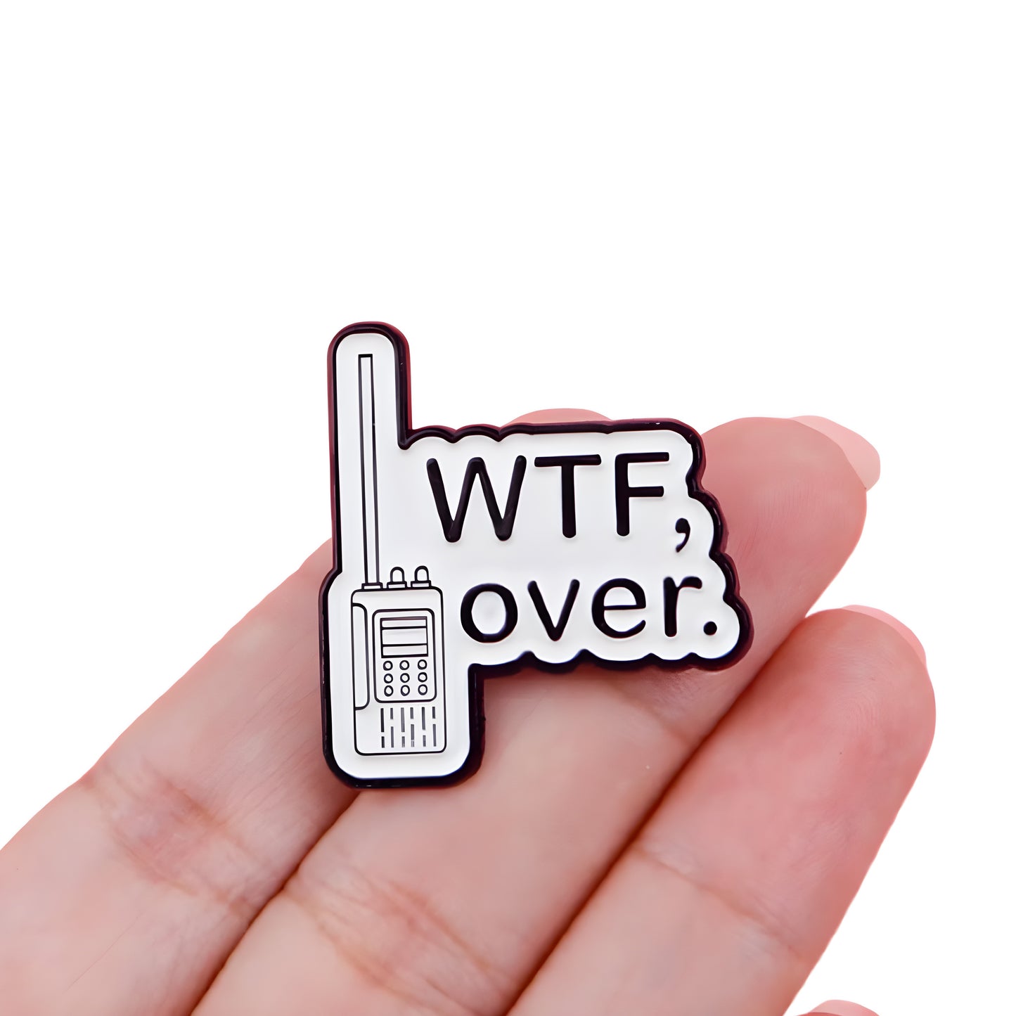 Funny WTF, Over enamel pin with retro walkie-talkie design and sarcastic humor text, held in a hand