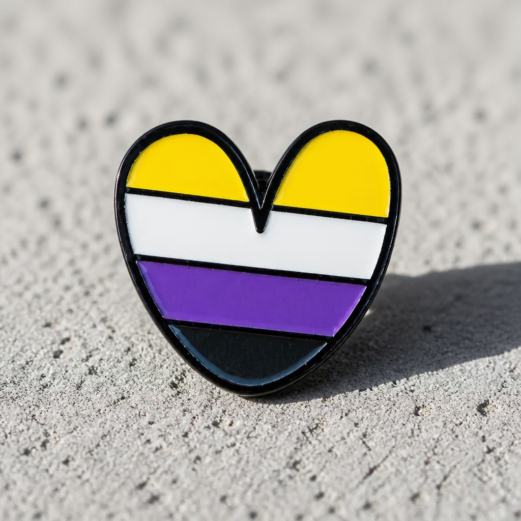 Nonbinary Pride Heart Enamel Pin - Heart-shaped pin with a non-binary pride flag design on a concrete surface