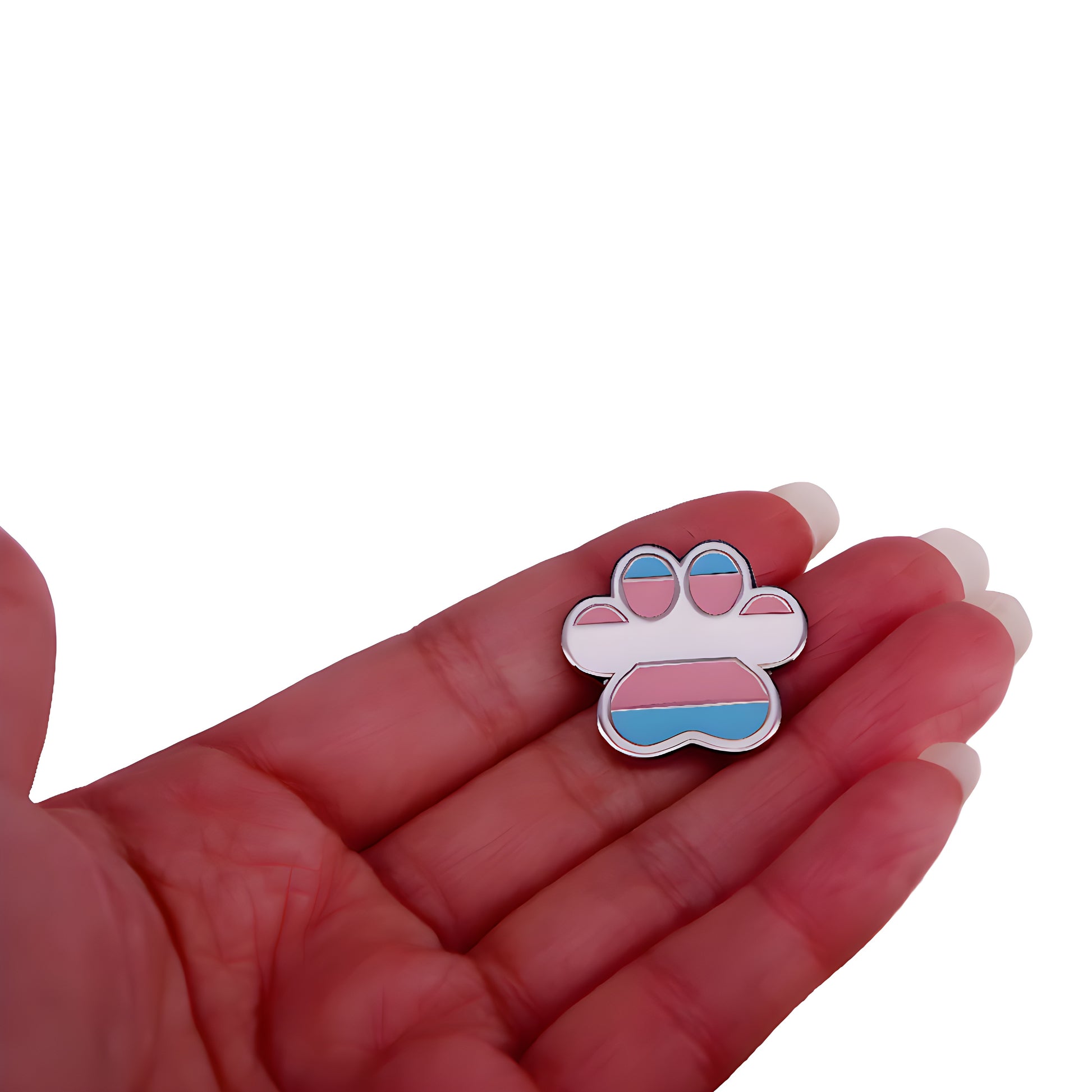 Transgender pride paw print enamel pin with light blue pink and white flag colors held in a hand