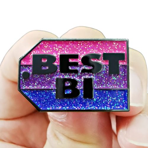 Glitter bisexual Pride enamel pin reading “Best Bi” in bold lettering held between fingers